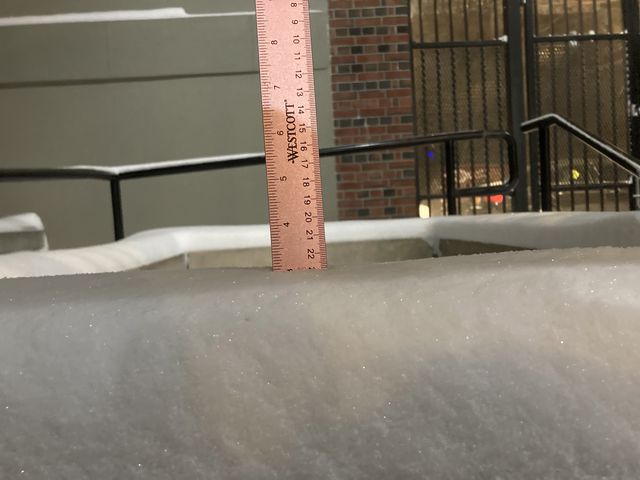 A ruler stuck in the snow showing about three inches of snow fell.